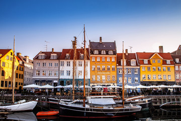 Fototapeta na wymiar COPENHAGEN, DENMARK - MAY 6, 2018: scenic view of beautiful colorful buildings and boats moored in harbor, copenhagen, denmark