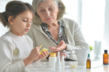 Cute girl and sick senior woman