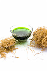 Close up of dark green colored herbal syrup of Khus or vetiver grass isolated on white in a...