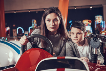 Fototapeta na wymiar Concentrated mother and son driving toy car