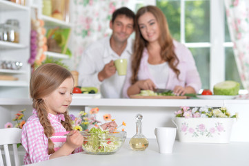 Obraz na płótnie Canvas Cute little daughter preparing salad