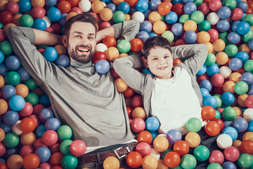 Fototapeta na wymiar Top view. Happy dad and son in pool with balls