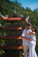 bride and groom posing in front of old Asian temple