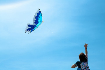 Girl is running the flying kite in the sky
