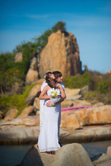 the bride and groom stand against a beautiful landscape