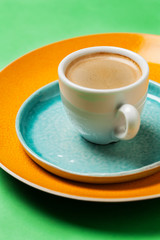 Cup of coffee on colorful tableware