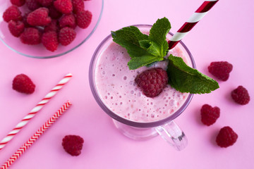 Raspberries  milkshake in the glass on the pink  background.Top view.