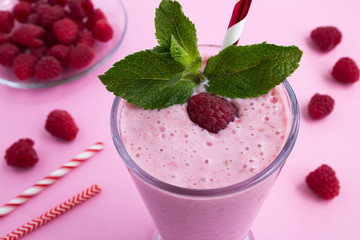Raspberries  milkshake in the glass on the pink  background.Top view.