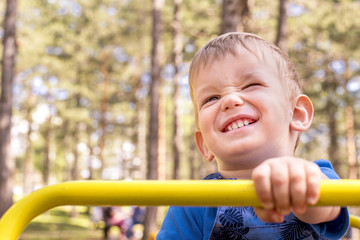 Fototapeta na wymiar Portrait of beautiful little boy having fun in the playground
