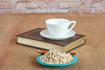 Oats flakes in dish on wood table