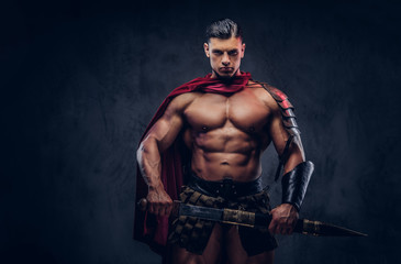 Obraz na płótnie Canvas Brutal ancient Greece warrior with a muscular body in battle uniforms