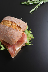 sandwich with prosciutto jamon on a stone background