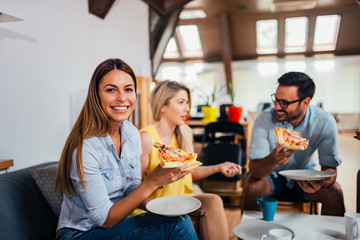 Happy business team eating pizza in the office.