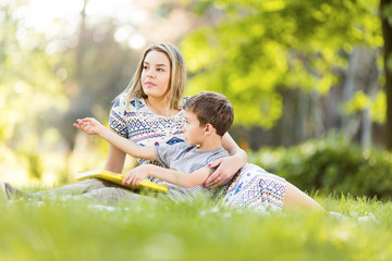 Fototapeta premium Mother and son in park with book