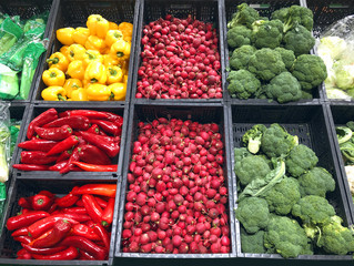 different vegetables, red peppers, radishes, broccoli in a boxes in supermarket