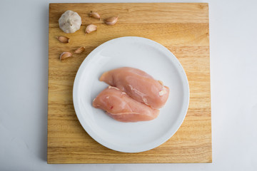 Raw chicken breast fillets on white dish