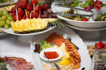 Buffet table of reception with cold snacks, shrimp, fish, caviar