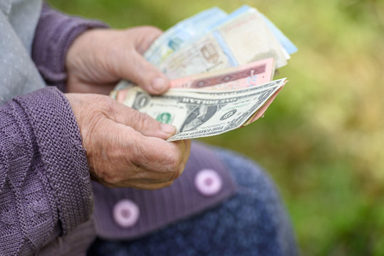 The old woman considers banknotes - hands and money close up