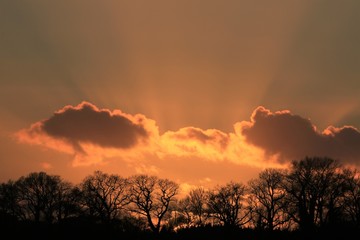 blood red sky with sun rays shining through clouds, copy space
