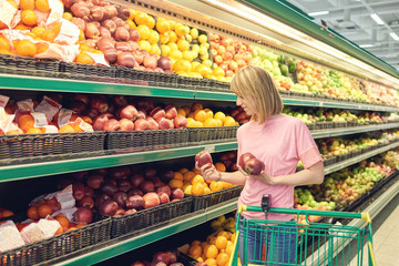 Slender young woman shopping healthy food in supermarket.
