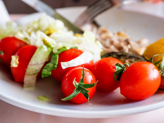 Healthy dinner - plate full of stewed vegetables and grilled tomatoes.