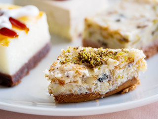 White plate full of different pastries. Tasty desserts with topping, pistachios.