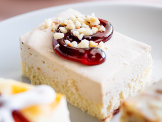 White plate full of different pastries. Tasty desserts with topping, coconut flakes.