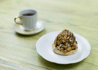 Coffee in a retro cup and cake on a wooden background.