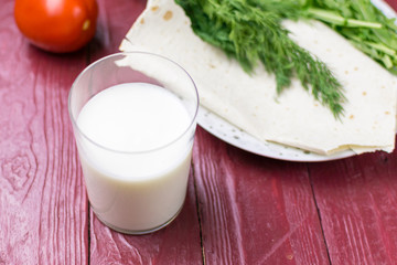 A glass of yogurt (kefir) and fresh vegetables. The concept of diet and healthy eating.