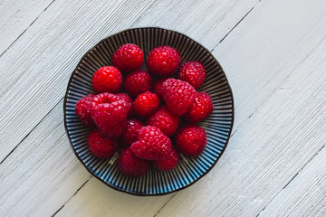 Centered Bowl of Raspberries on White Table
