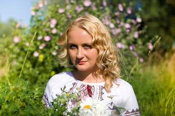 Beautiful  girl in national Ukrainian embroidery shirt and wreath of wild flowers. Holiday of Ivan Kupala in Ukraine.