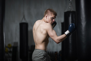 Fototapeta na wymiar Young boxer training with punching bag