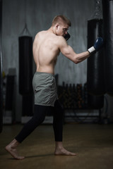 Young boxer training with punching bag