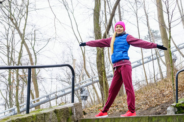 Sporty girl stretching outdoor in park.