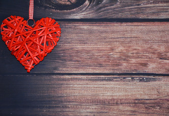 Red wicker heart on wooden background