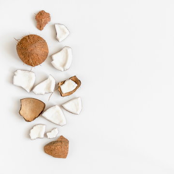 Pieces of coconut on white background. Flat lay, top view, copy space 