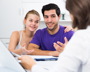 Loving couple with female designer at home