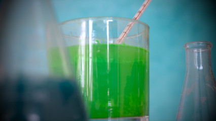 Flasks, test tubes with test different compositions, green background.	