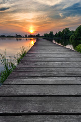 Wooden path over the lake at sunset