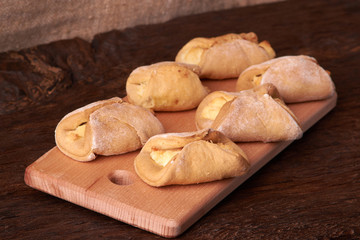 Baking cheesecakes with cottage cheese. blush baking on wooden table. sweet and tasty cookies on black background