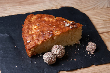 Apple pie tart on shale board with raisins, nuts and cinnamon is a vintage wooden background texture. Rustic style
