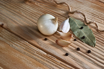 Garlic, onion, bay leaf, black pepper on a wooden table. Food background. Garlics. sliced garlic, garlic clove, garlic bulb.