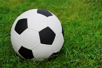 Fototapeta na wymiar soccer ball on the field with green grass. Copy space.