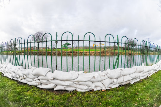 Sandbags Are Placed Beside A River About To Burst Its Banks