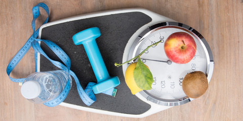 flat lay scale weighs person with water bottle fruit dumbbells and a meter symbol of good hygiene of life to lose weight in top view