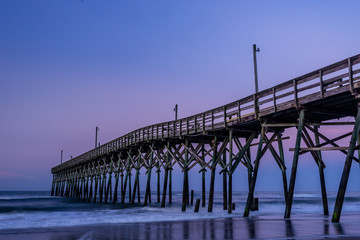 morning light shining on fishing pier along the North Carolina coast in Holden Beach