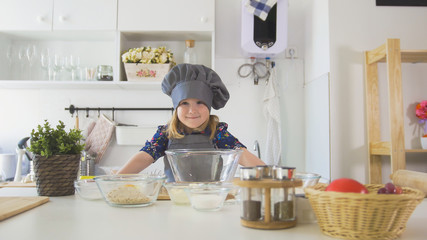 Portrait of little girl baker on kitchen