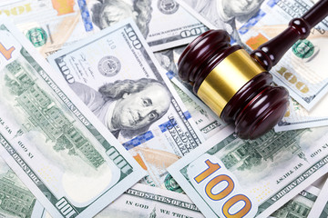 Wooden judge gavel on hundred dollar banknotes background
