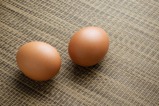 Brown chicken egg on bamboo mat
