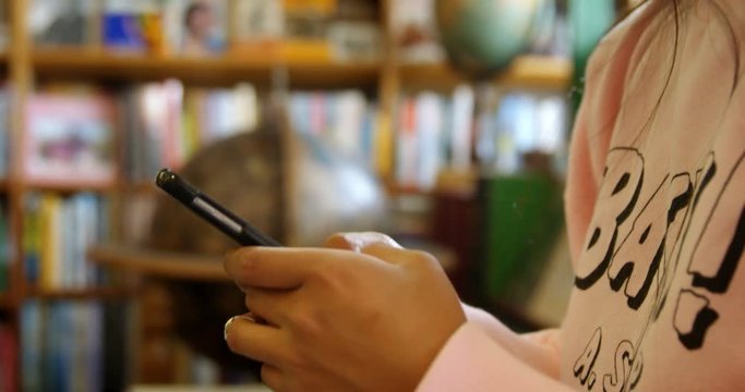 Teenage girl using digital tablet in library 4k